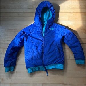 The North Face Kids Blue and Teal Puffer Jacket. The jacket is reversible.